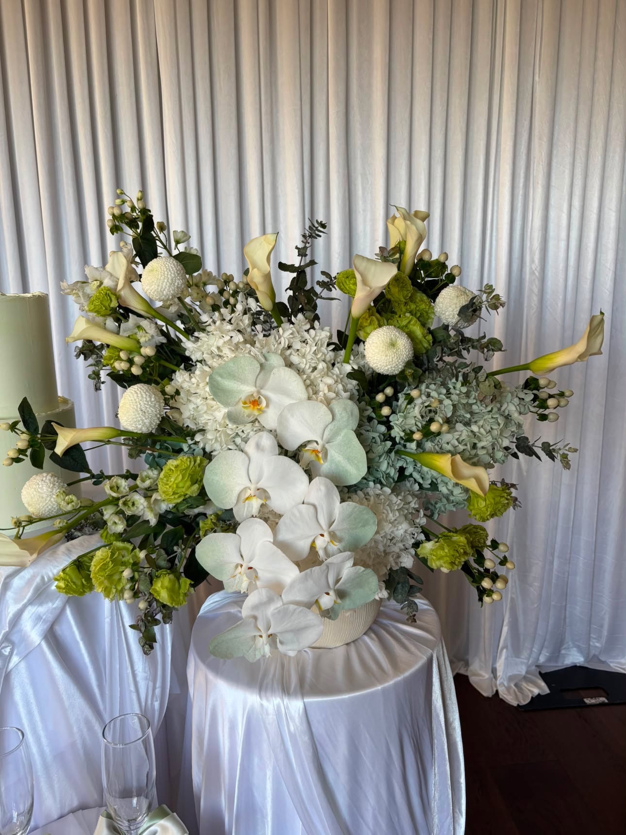Large white and green reception arrangement with orchids and calla lilies