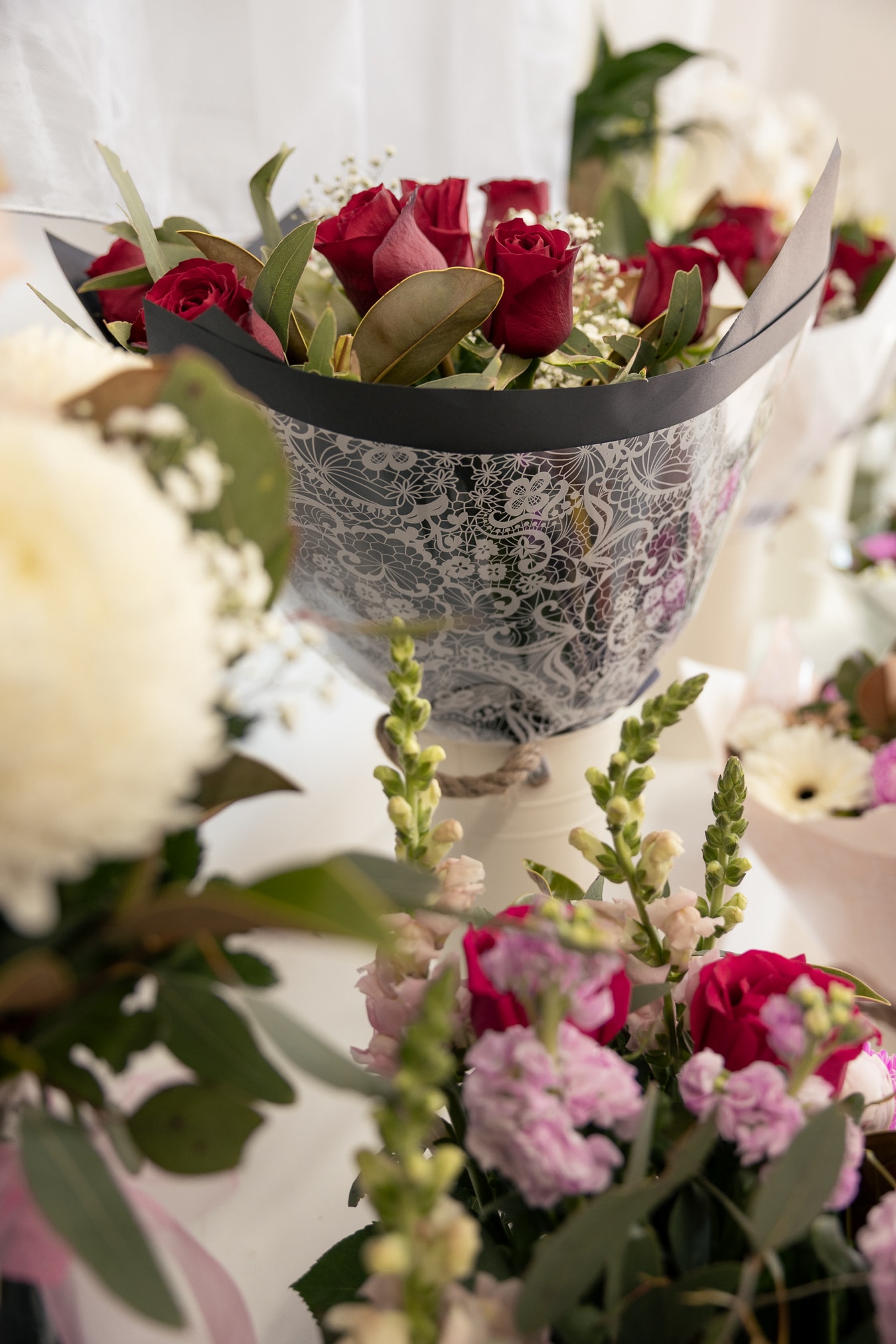 Bouquet of red roses in a black and white lace-patterned wrap