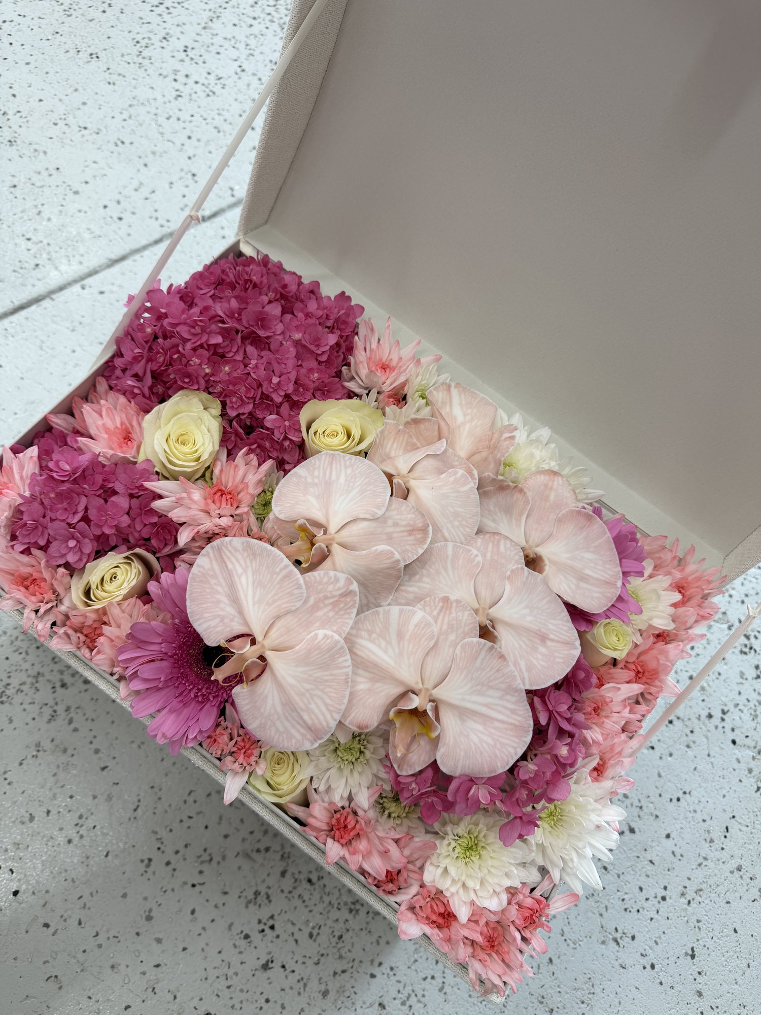 Gender reveal flower box of pink orchids, roses and hydrangea