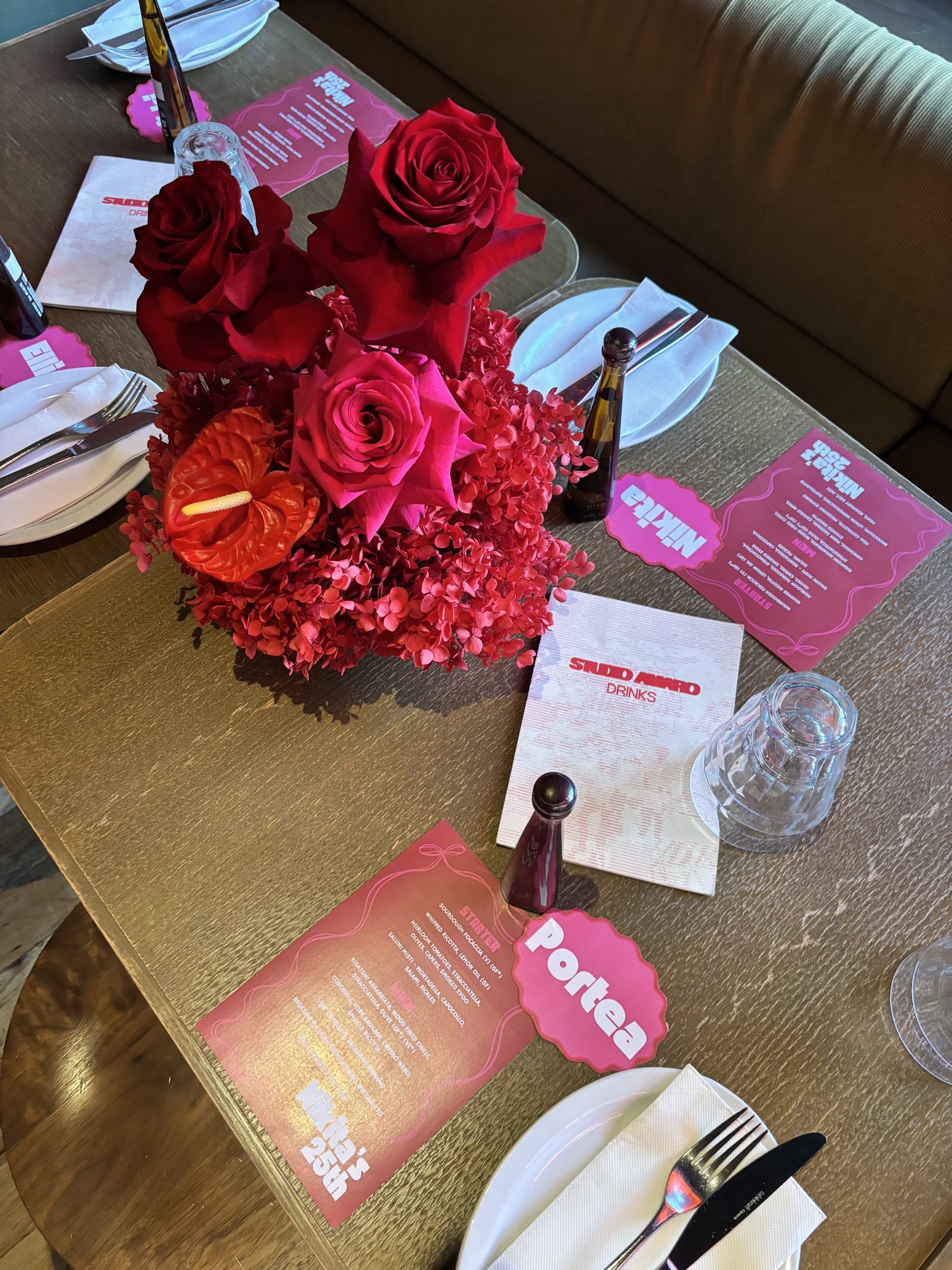 Red rose, anthurium and hydrangea table piece on a set event table