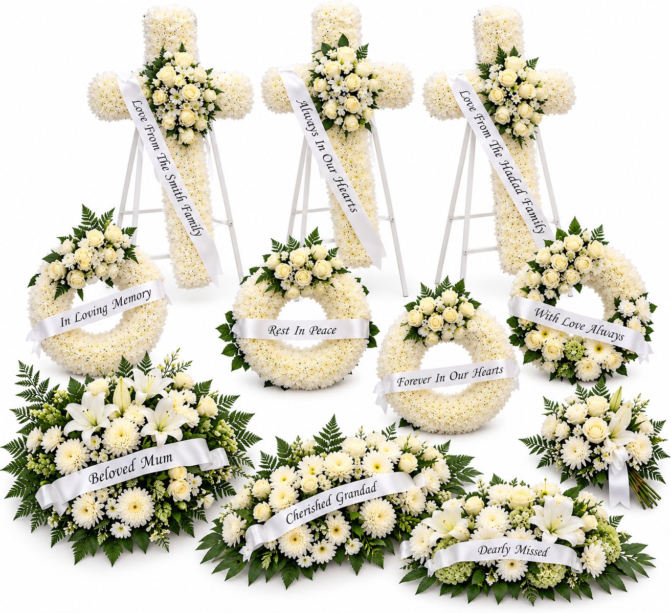 White standing crosses, wreaths and flat tributes with message ribbons