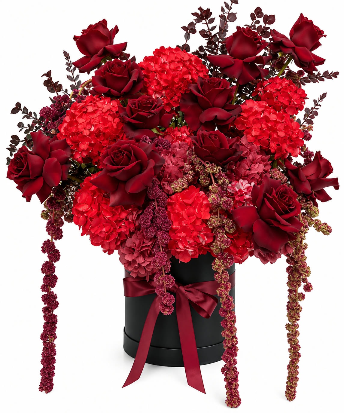 Red rose and hydrangea arrangement in a black hat box with trailing amaranthus